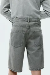 Bermuda de cinco bolsillos en denim de algodón grueso. Modelo de cintura estándar con cierre y botón, y piernas de corte relajado.