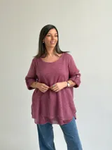 Sweater Ginebra de punto color magenta, con escote redondo, mangas largas con presilla y botón para ajustar, y diseño holgado con bajo asimétrico.
