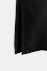 Vestido midi negro confeccionado en hilatura de viscosa, de diseño satinado y corte asimétrico con escote fluido y manga sisa. Presenta bajo acabado en línea evasé y cierre lateral con cremallera oculta en costura.