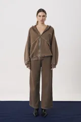 Campera con capucha y cierre frontal, confeccionada en tejido de punto con efecto lavado. Presenta mangas largas con puños ajustados y un corte relajado.