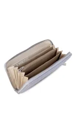 Billetera de dama en símil cuero color negro, de diseño acolchado con costuras verticales que forman relieves y cierre perimetral. Incluye monograma en la esquina inferior y viene con caja de presentación estampada.