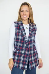 Chaleco de corte recto con diseño escocés en tonos azul, rojo y blanco. Presenta solapas clásicas, cierre frontal con botones y bolsillos laterales. Está confeccionado en algodón con forro interior de satén.