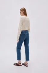 Pantalón jean gris oscuro de corte slim fit y tiro alto, con diseño clásico de cinco bolsillos.