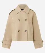 Trench coat corto de la marca Cortelle, confeccionado en una mezcla de algodón y poliéster con estructura de lona. Presenta un diseño de abotonado cruzado, cuello clásico, mangas largas con trabillas en los puños y bolsillos frontales.