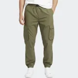 Pantalón cargo de nylon color verde oliva, con cintura elástica ajustable, bolsillos laterales con solapa y puños elásticos en los tobillos. Presenta un pequeño logo estampado en uno de los bolsillos laterales.