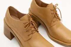 Zapato acordonado de cuero color marrón chocolate, con punta cuadrada y tacón ancho.