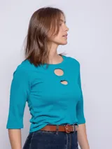 Top de manga tres cuartos con cuello redondo y detalle de aberturas cut-out en el escote.