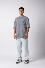 Remera oversize de algodón pesado, color gris oscuro con efecto lavado 'snow' que le da un aspecto gastado y único. Presenta cuello redondo y costuras vistas en hombros y mangas.