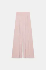 Pantalón fluido de tiro alto con cintura elástica y pernera ancha, de color rosado.