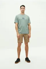 Remera de manga corta color verde agua con estampado gráfico en la espalda que incluye texto y motivos playeros. Confeccionada en algodón con calce regular.