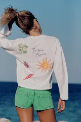 Remera blanca de manga larga y cuello redondo con detalle de texto impreso en el pecho en color azul.
