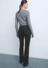 Pantalón de jean estilo flare de tiro medio, con cierre frontal de cremallera y botón, diseño de cinco bolsillos y acabado con bajo desflecado.