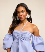 Blusa celeste de tricolina con hombros descubiertos, mangas abullonadas cortas y lazo en el cuello y parte delantera.