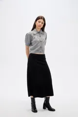 Saco de punto gris con cuello tipo camisa, manga corta y cierre frontal con botones. Presenta un delicado bordado de flores blancas en la parte superior delantera.