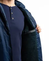 Campera outdoor de color negro, con diseño funcional y robusto. Cuenta con capucha forrada en micropolar, cierre frontal cubierto por tapeta con botones a presión, bolsillos laterales y en el pecho con cierre, y puños y cintura elásticos para un mejor ajuste.