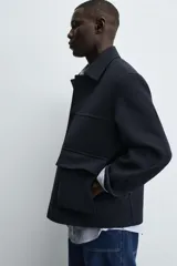 Chaquetón de corte regular fit, con cuello solapa, manga larga y cierre frontal con botones. Presenta dos bolsillos de plastrón con solapa en la parte frontal y un bolsillo interior.