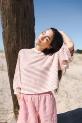 Remera de mangas largas a rayas horizontales verdes y blancas, de corte amplio y cuello redondo.