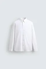 Camisa de corte regular fit confeccionada en popelín de algodón. Presenta cuello abotonado, manga larga con puños ajustables mediante botón y cierre frontal de botonadura completa.