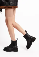 Botas Chelsea negras de cuero vacuno con elásticos laterales, caña media y suela track.