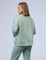 Buzo blanco de tejido elastizado, con pespunte central en la parte delantera y tajos laterales.