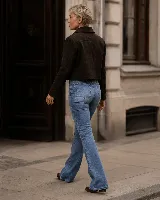 Jean Oxford de tiro alto y lavado azul medio, con diseño de cinco bolsillos y pierna que se ensancha progresivamente desde la rodilla.