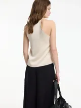 Top musculosa de corte recto con escote en V pronunciado y tirantes finos. Presenta un diseño minimalista y elegante, confeccionado en una mezcla de ácido acético y poliéster con forro interior.