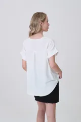 Blusa de poliéster color blanco con cuello en V, mangas cortas con dobladillo y corte holgado.