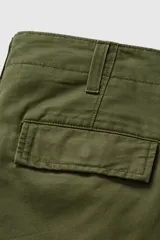 Pantalón cargo de corte recto en color verde oliva, con bolsillos laterales tipo cargo y cierre frontal con botón y cremallera.