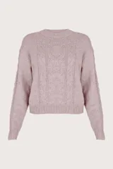Suéter rosa de cuello redondo, con tejido de cable al frente y a los costados, y pequeñas lentejuelas integradas en el tejido.