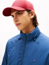 Campera acolchada de hombre, color azul marino, con cuello alto y cierre frontal de cremallera. Presenta bolsillos laterales con cierre y el logo de Tommy Hilfiger bordado en el pecho.