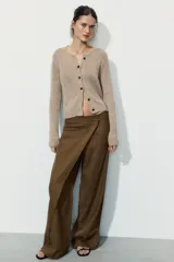 Pantalón de tiro medio confeccionado en mezcla de lino, con diseño de pierna recta y detalle de superposición frontal tipo pareo. Cuenta con cierre frontal mediante cremallera, botón y gancho metálico.