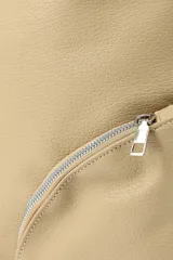 Bandolera de cuero sintético color beige con diseño de hombro, caracterizada por dos bolsillos frontales con cierre metálico en diagonal.