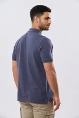 Remera polo de piqué de algodón color azul, de manga corta, con cuello camisero, cierre frontal de dos botones y pequeño logo bordado en el pecho.