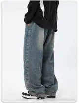 Pantalón de jean de corte ancho y tiro alto, color celeste desgastado. Presenta costuras decorativas en contraste, paneles superpuestos en las rodillas y cordón de ajuste blanco en la cintura elástica.