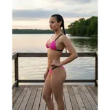 Bikini de dos piezas con estampado de corazones negros sobre fondo fucsia. El top es de estilo triángulo con tiras negras, y la parte inferior es una tanga con tiras laterales negras.