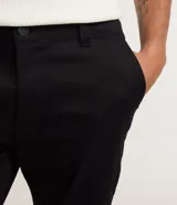 Pantalón slim de sarga color beige para hombre, con cintura con trabillas, cierre tradicional y bolsillos laterales y traseros.