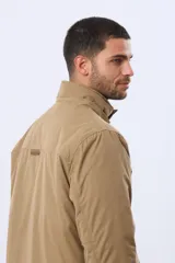 Campera de abrigo color azul marino, con capucha desmontable, cierre frontal con solapa, bolsillos frontales con solapa y detalle de etiqueta de cuero sintético. Cuenta con interior forrado en corderito en la parte superior para mayor calidez.
