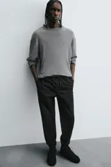 Pantalón tipo jogger de corte slim fit, confeccionado en tejido de algodón con elasticidad. Presenta cintura elástica ajustable con cordón, bolsillos frontales, bolsillos traseros de vivo y bajos con puños elásticos.