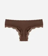 Bombacha de bikini hilo de tiro bajo y laterales medianos, confeccionada en poliamida sin costuras con textura acanalada y detalles de encaje en las aberturas.