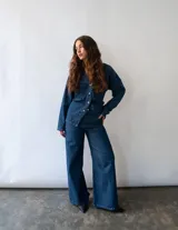 Pantalón de jean color azul oscuro, de corte wide leg y tiro medio-alto. Presenta bolsillos cuadrados frontales y diseño de estilo vintage.