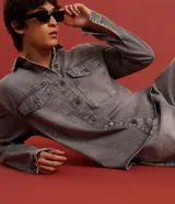 Camisa masculina de denim de algodón con efecto marmolado, corte oversized tipo boxy, cuello camisero, mangas largas, cierre frontal con botones y dos bolsillos frontales con solapa en el pecho.