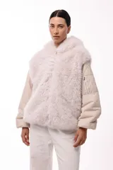 Campera de invierno con frente de piel sintética y capucha integrada, combinada con mangas acolchadas de estilo puffer en color marrón oscuro.