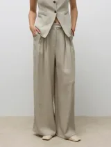 Pantalón sastrero de tiro alto color beige, con cierre de gancho y cremallera, bolsillos laterales y un fit relajado. Confeccionado en tejido chambray.