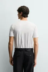 Camiseta blanca de algodón con elasticidad, corte slim fit, cuello en V y mangas cortas.