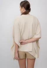 Ruana color crudo de tejido de punto con textura, hecha de 100% baby alpaca.