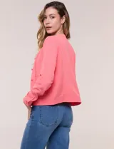 Camperita de tela liviana color beige, de silueta entallada con cuello a la base y abotonadura frontal con botones a tono. Cuenta con dos bolsillos con solapa en el frente, mangas largas con puños abotonados y largo a la cintura.