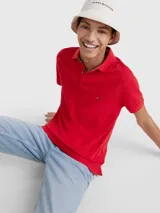 Chomba roja Tommy Hilfiger 1985 de corte regular, con cuello tipo chomba, cartera de dos botones, logo de Tommy Hilfiger bordado en el pecho y detalles distintivos de la marca.