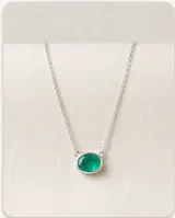 Collar de plata con cadena fina de eslabones y un dije ovalado con piedra natural turmalina de color verde.