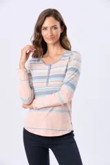 Remera de manga larga con estampado de rayas horizontales en tonos rosado, celeste y gris. Presenta un escote redondo con una pequeña abertura frontal con botones y un corte ligeramente redondeado en el ruedo.