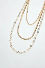 Collar de tres tiras de cadena dorada con diferentes diseños: una cadena fina de eslabones clásicos, una tira plana tipo escama de pescado y una cadena con eslabones en forma de trébol o flor.
